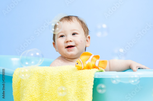 Photo: adorable baby taking bath in blue tub adorable baby taking bath in blue tub