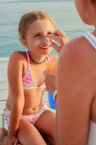 Photo: Sun protection - Mother anoints her daughter face sunblocker Sun protection - Mother anoints her daughter face sunblocker
