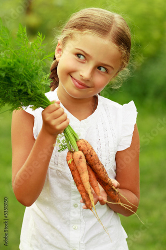 Photo: Gardening - lovely girl with bunch of carrots Gardening - lovely girl with bunch of carrots