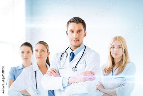 Photo: male doctor in front of medical group male doctor in front of medical group