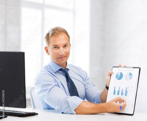 Photo: businessman showing graphs and charts businessman showing graphs and charts