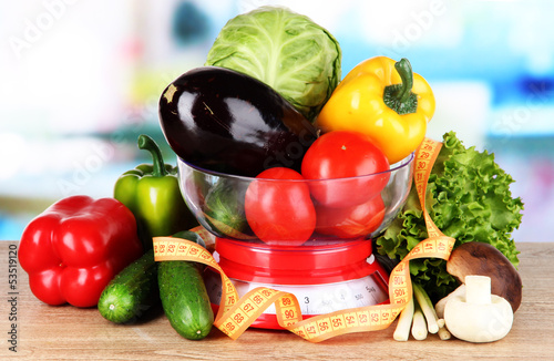 Photo: Fresh vegetables in scales on table in kitchen Fresh vegetables in scales on table in kitchen