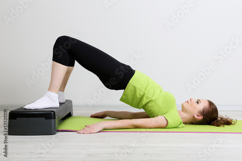 Photo: Beautiful young woman exercises on stepper Beautiful young woman exercises on stepper