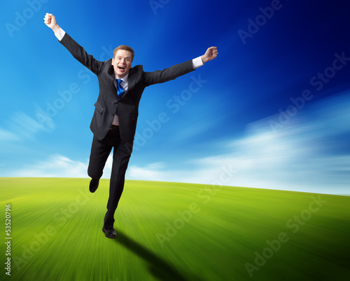 Photo: happy business man running on blured spring field happy business man running on blured spring field