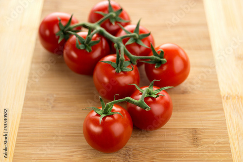 Photo: Ripe cherry tomatoes on a wooden board Ripe cherry tomatoes on a wooden board