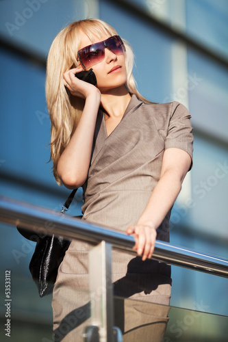 Photo: Blond woman calling on the phone Blond woman calling on the phone