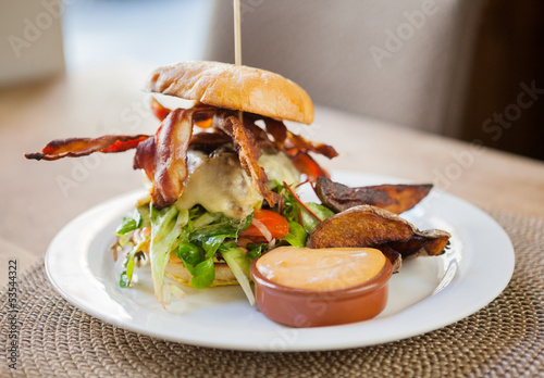 Photo: Bacon Burger on Plate in Restaurant Bacon Burger on Plate in Restaurant