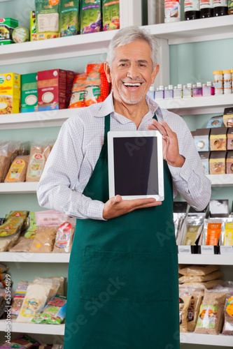 Photo: Male Owner Showing Digital Tablet In Store Male Owner Showing Digital Tablet In Store
