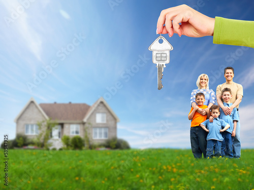 Photo: Happy family near new house. Happy family near new house.