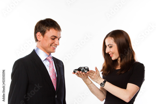 Photo: young man and woman are holding a toy car young man and woman are holding a toy car