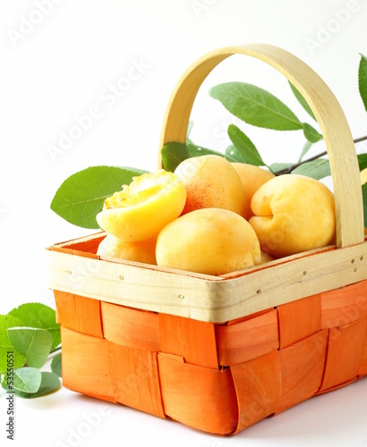 Photo: yellow sweet ripe apricots (peaches) with green leaves yellow sweet ripe apricots (peaches) with green leaves
