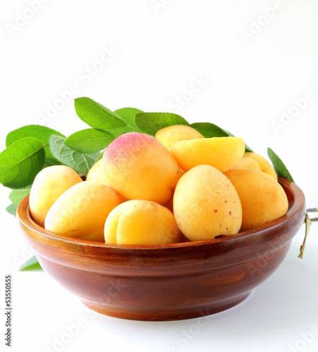 Photo: yellow sweet ripe apricots (peaches) with green leaves yellow sweet ripe apricots (peaches) with green leaves
