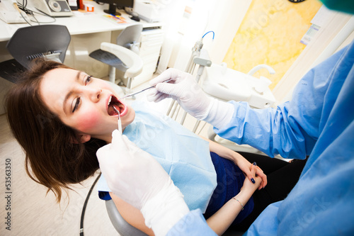 Photo: Dentist doing a treatment Dentist doing a treatment