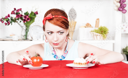 Photo: Woman choosing between healthy food and cake Woman choosing between healthy food and cake