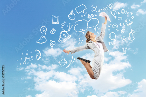 Photo: Businesswoman holding papers and jumping Businesswoman holding papers and jumping