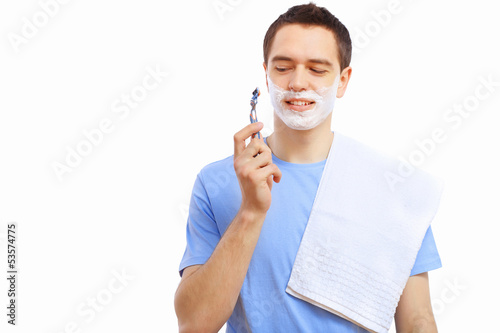 Photo: Young man at home shaving himself Young man at home shaving himself