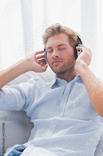 Photo: Man relaxing while listening to music on a couch Man relaxing while listening to music on a couch
