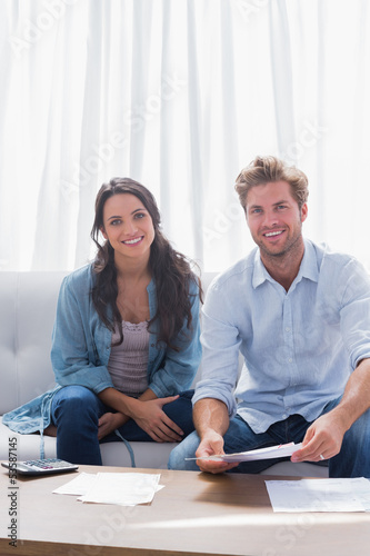 Photo: Couple smiling while doing their accounts Couple smiling while doing their accounts