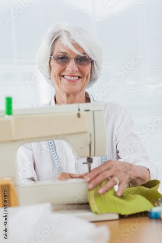 Photo: Woman using the sewing machine Woman using the sewing machine