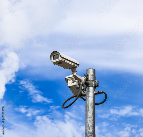 Photo: surveillance camera against blue sky surveillance camera against blue sky