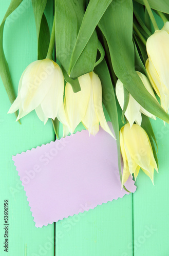 Photo: Beautiful white tulips on color wooden background Beautiful white tulips on color wooden background