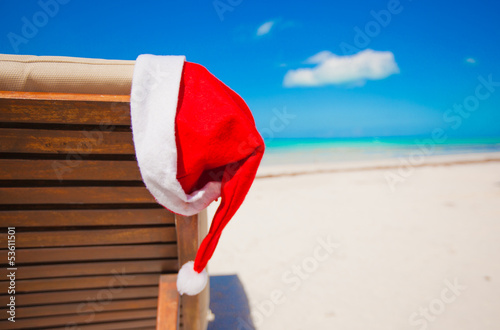 Photo: Close-up santa hat on chair longue on tropical caribbean beach Close-up santa hat on chair longue on tropical caribbean beach