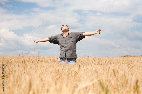 Photo: young farmer in a wheat field young farmer in a wheat field