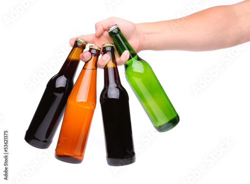 Photo: four beer bottles in different colours and hand four beer bottles in different colours and hand