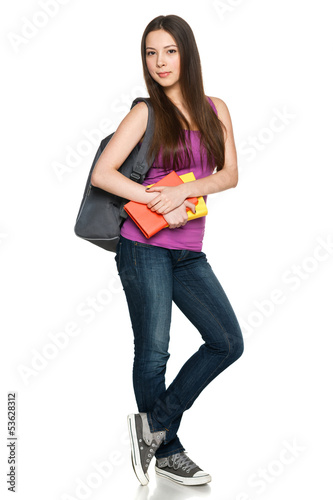 Photo: Smiling teen girl wearing backpack and holding books Smiling teen girl wearing backpack and holding books