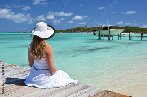 Photo: Girl on the wooden jetty looking to the ocean. Exuma, Bahamas Girl on the wooden jetty looking to the ocean. Exuma, Bahamas