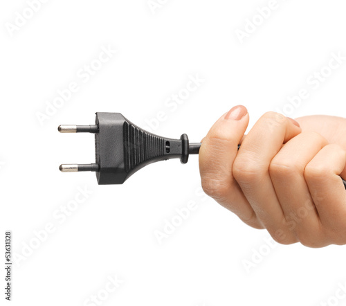 Photo: hand holding black electrical plug with wire hand holding black electrical plug with wire