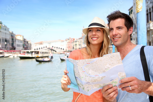 Photo: Cheerful tourists with city map in Venice Cheerful tourists with city map in Venice