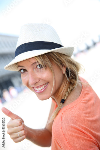 Photo: Smiling beautiful girl with hat showing thumb up Smiling beautiful girl with hat showing thumb up