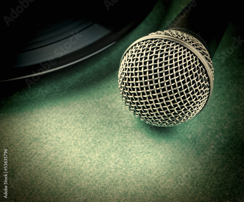 Photo: microphone and old vinyl record on a green background microphone and old vinyl record on a green background