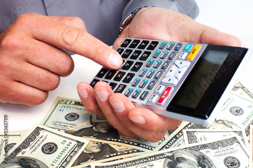 Photo: Hand with calculator and money. Hand with calculator and money.