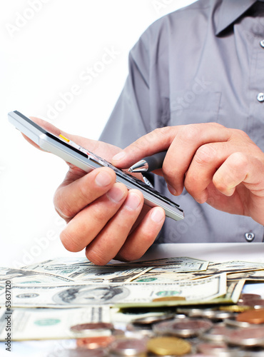 Photo: Hand with calculator and money. Hand with calculator and money.