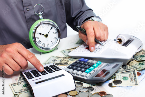 Photo: Hand with calculator and money. Hand with calculator and money.