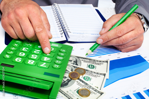 Photo: Hand with calculator and money. Hand with calculator and money.
