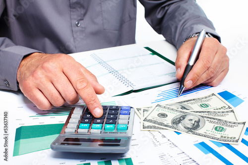 Photo: Hand with calculator and money. Hand with calculator and money.