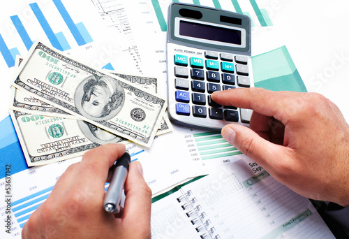 Photo: Hand with calculator and money. Hand with calculator and money.
