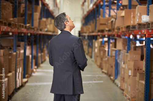 Photo: Rear View Of Manager In Warehouse Rear View Of Manager In Warehouse