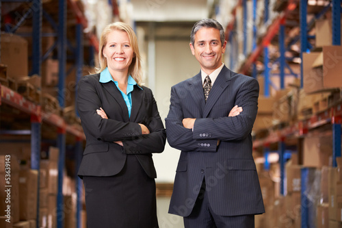 Photo: Businesswoman And Businessman In Distribution Warehouse Businesswoman And Businessman In Distribution Warehouse