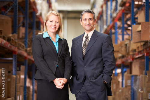 Photo: Businesswoman And Businessman In Distribution Warehouse Businesswoman And Businessman In Distribution Warehouse