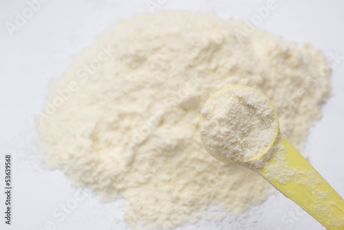 Photo: powder milk and yellow spoon powder milk and yellow spoon
