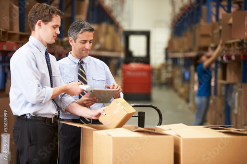 Photo: Businessmen Checking Boxes With Digital Tablet And Scanner Businessmen Checking Boxes With Digital Tablet And Scanner
