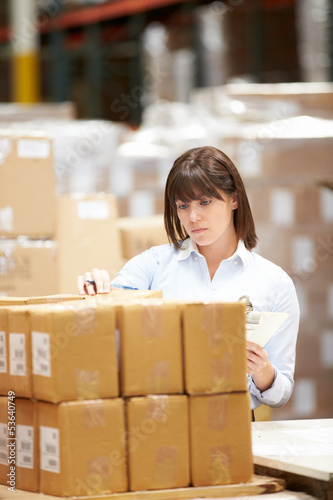 Photo: Worker In Warehouse Preparing Goods For Dispatch Worker In Warehouse Preparing Goods For Dispatch