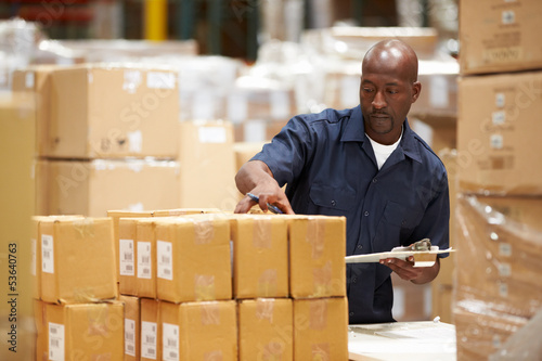 Photo: Worker In Warehouse Preparing Goods For Dispatch Worker In Warehouse Preparing Goods For Dispatch