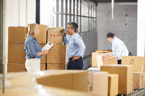 Photo: Workers Checking Goods On Belt In Distribution Warehouse Workers Checking Goods On Belt In Distribution Warehouse