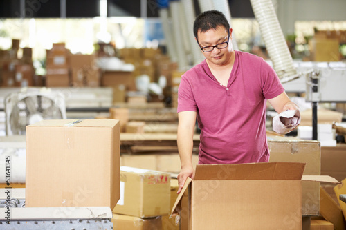 Photo: Worker In Warehouse Preparing Goods For Dispatch Worker In Warehouse Preparing Goods For Dispatch