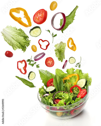 Photo: Falling fresh vegetables. Healthy salad isolated Falling fresh vegetables. Healthy salad isolated